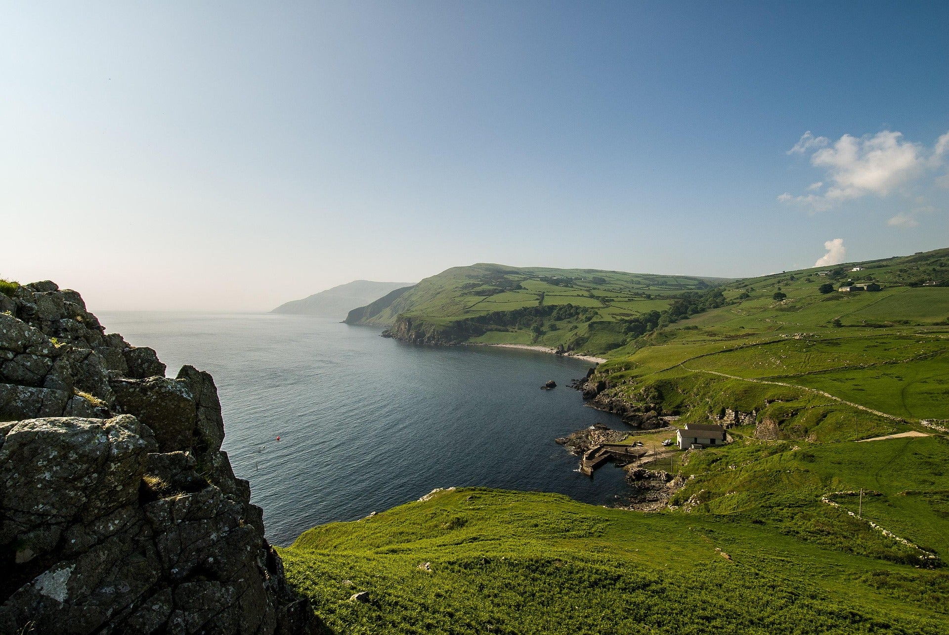 Scenic view of the Irish coastline with cliffs, rolling green hills, and a small fishing pier – showcasing the natural beauty of Ireland.
Radharc álainn ar chósta na hÉireann le haillte, cnoic ghlasa rollta, agus cé beag iascaigh – ag léiriú áilleacht nádúrtha na hÉireann.