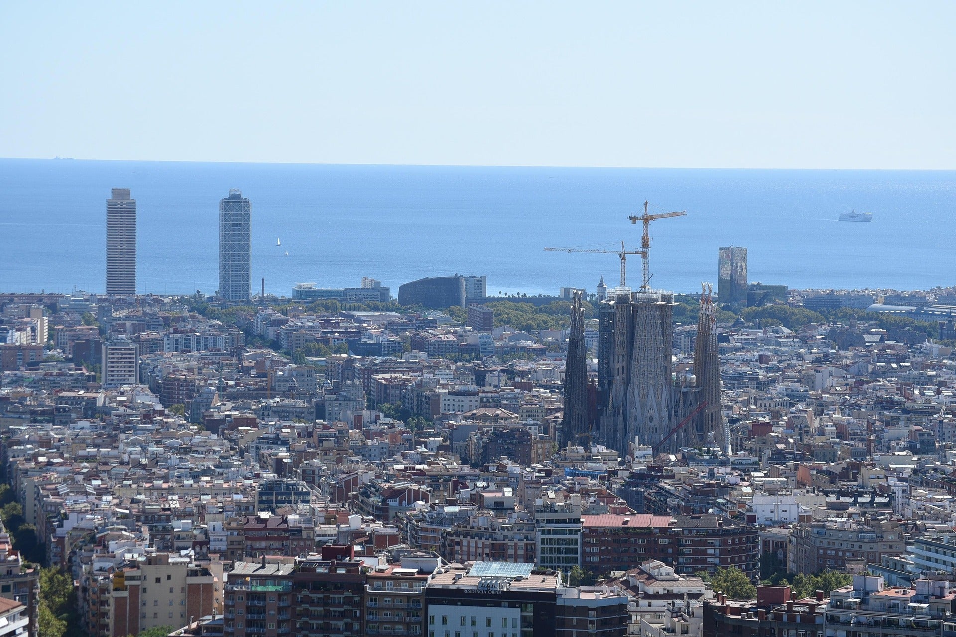 🏙️ Vista de Barcelona amb la Sagrada Família i el mar Mediterrani al fons.