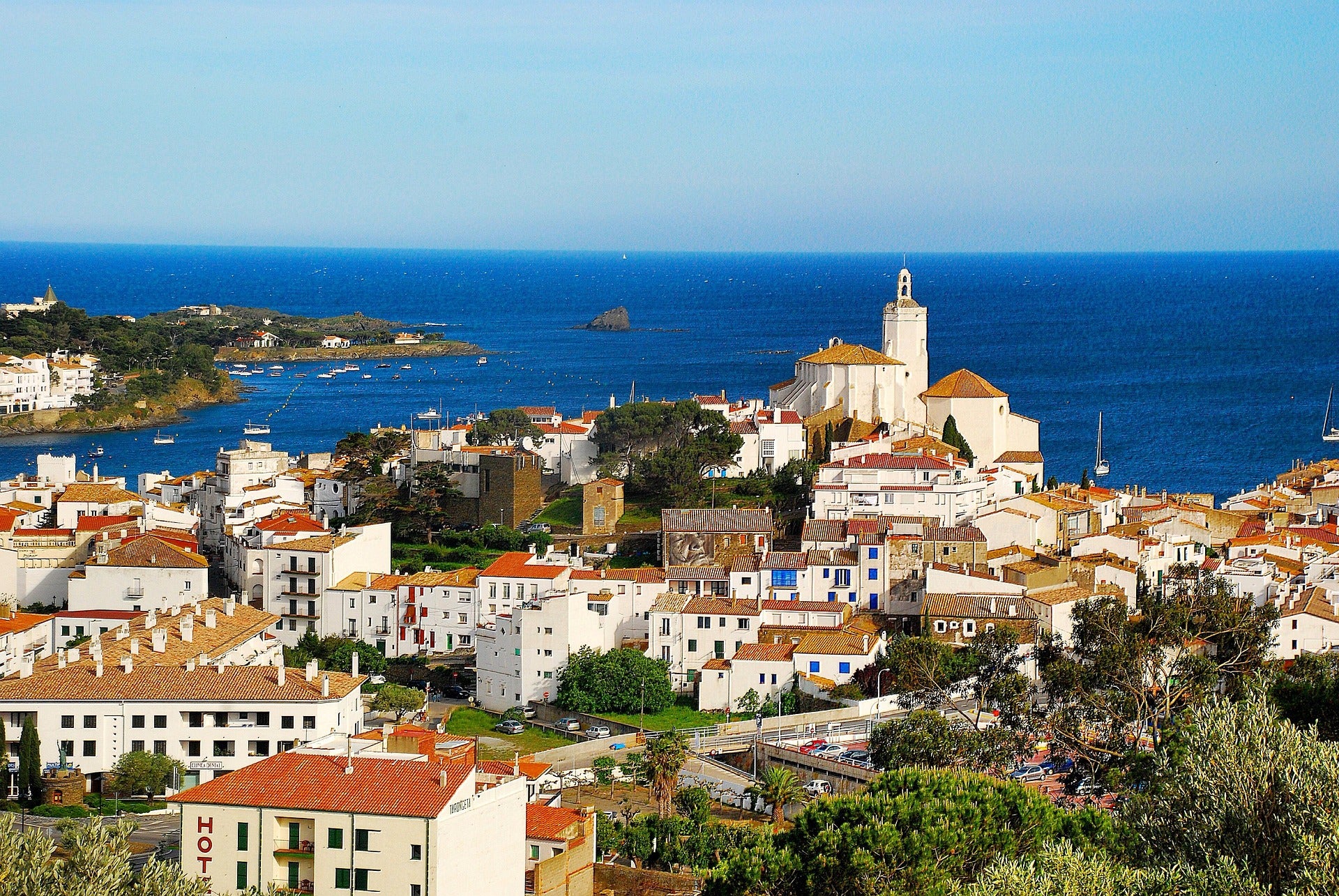 🏖️ Cadaqués, un poble costaner de la Costa Brava amb teulades vermelles i església blanca davant del mar.