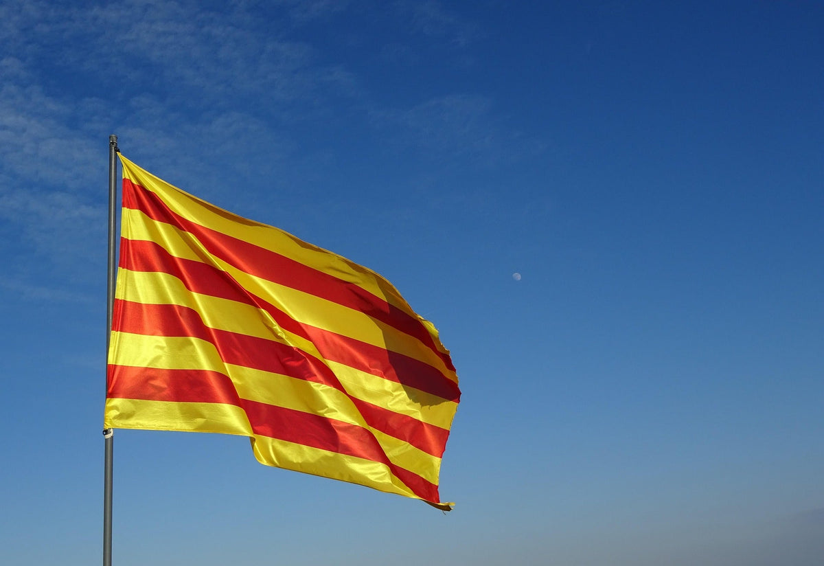 🟥🟨 La senyera catalana onejant al vent sota un cel clar i blau.