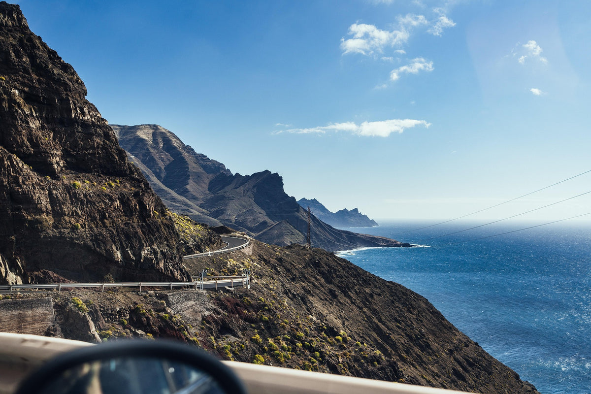 Costa rocosa de Las Palmas de Gran Canaria con fuerte presencia de productos promocionales para turismo, eventos y logística insular.