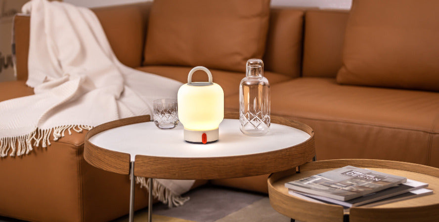 Load video: Kooduu design scene showing a softly lit Synergy lamp-speaker on a Scandinavian table in a warm living room. The video highlights the brand’s focus on sustainable design, energy efficiency, and modern aesthetics — reflecting the Nordic-Estonian partnership between Kooduu and Swish &amp; Click for eco-friendly branded merchandise.